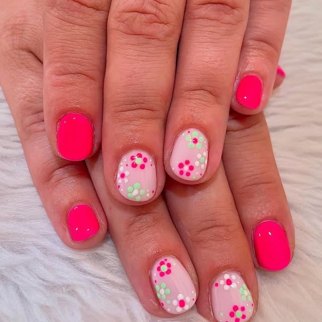 Neon pink nails with tiny flower accents
