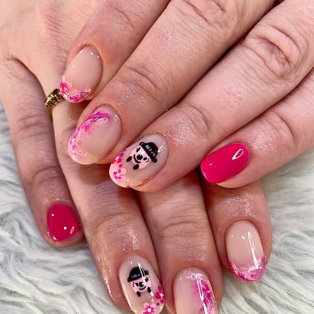 Pink floral french nails with a cow character accent